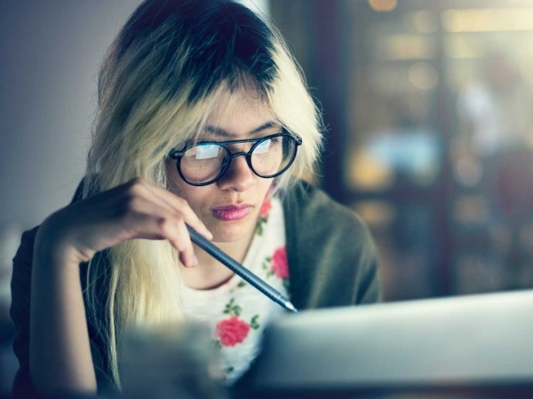Imagen de una mujer community manager delante de un ordenador)